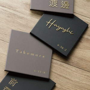グレーとブラックの2色のタイルにゴールド文字がおしゃれな表札。シンプルな正方形タイル表札｜タイル｜リコ